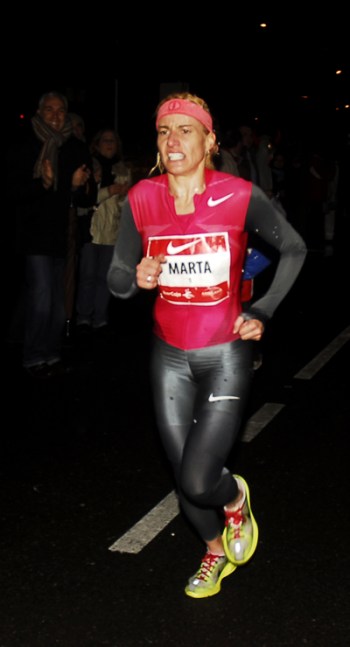 Memento Mori. El vértigo de la victoria, el deslumbramiento del éxito produce náuseas, es difícil vivir en un mundo de mortales cuando se ha rozado el paraíso, es difícil regresar al inframundo, al Hades, cuando se habita en los Campos Elíseos. Marta Domínguez fue utilizada por el poder (a ella no le importó, fue senadora por el PP) como ejemplo de persona luchadora, íntegra, de atleta entregada al sacrificio de la perfección, al sacerdocio del deporte purificador. Quizás midió mal sus capacidades y resbaló a punto de entrar en la meta de los triunfadores, se quedó a tres pasos de la gloria. Pasó de heroína a villana, de representar el éxito a equipararse al engaño, al fraude, su carrera política se arruinó, su carrera deportiva no tiene crédito. El pasado 19 de noviembre el Tribunal de Arbitraje del Deporte (TAS) la suspendió por tres años de la práctica deportiva (sin efectos posibles ya que estaba retirada de la competición) y la despojó de sus títulos deportivos por el uso de sustancias dopantes. Su caída a los infiernos de los falsos atletas, de los mentirosos, de los estafadores ha sido imparable, como Armstrong. En la foto aparece en la San Silvestre Vallecana, 31 de diciembre de 2009. Caronte aguarda vigilante en su barca sobre la laguna Estigia.